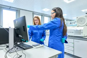 Picture of two UCB employees working in a laboratory analyzing scientific data 